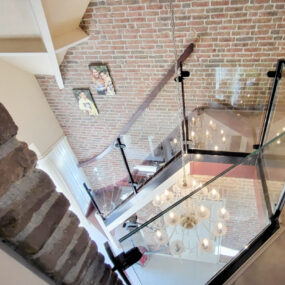 Glazen balustrade langs trap en overloop